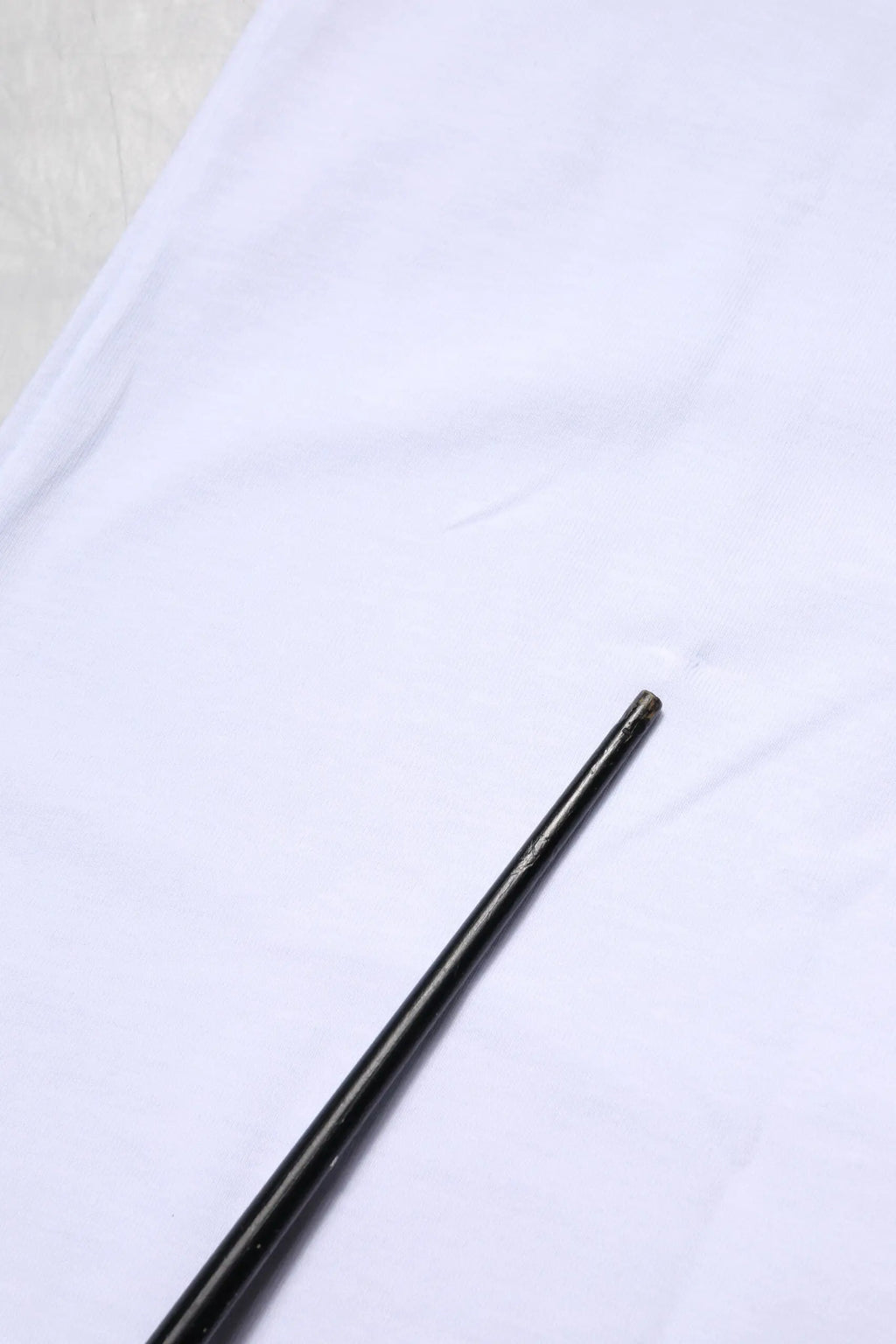 Noir baguettes lisses et brillantes posées en diagonale sur un t-shirt blanc en coton dolce gabbana goodluck 2023 col rond