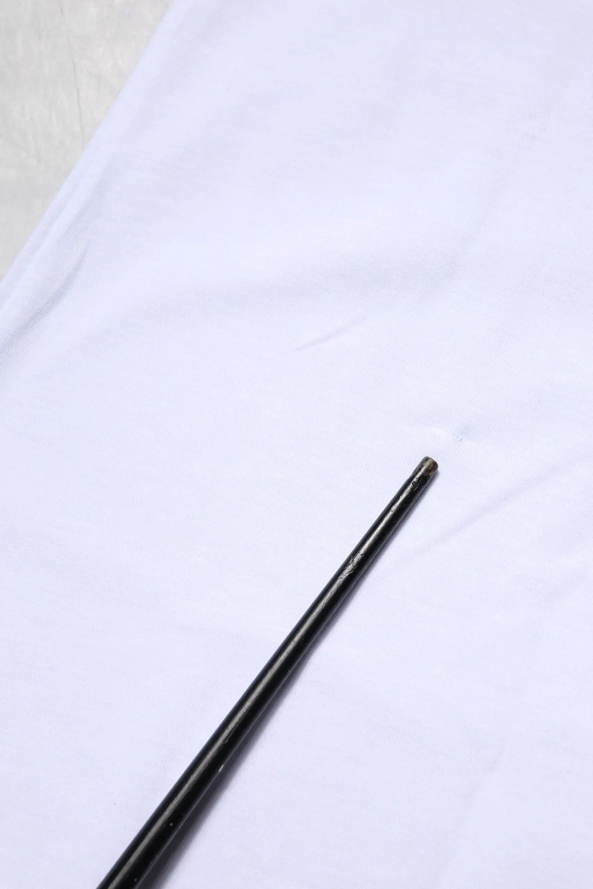 Noir baguettes lisses et brillantes posées en diagonale sur un t-shirt blanc en coton dolce gabbana goodluck 2023 col rond