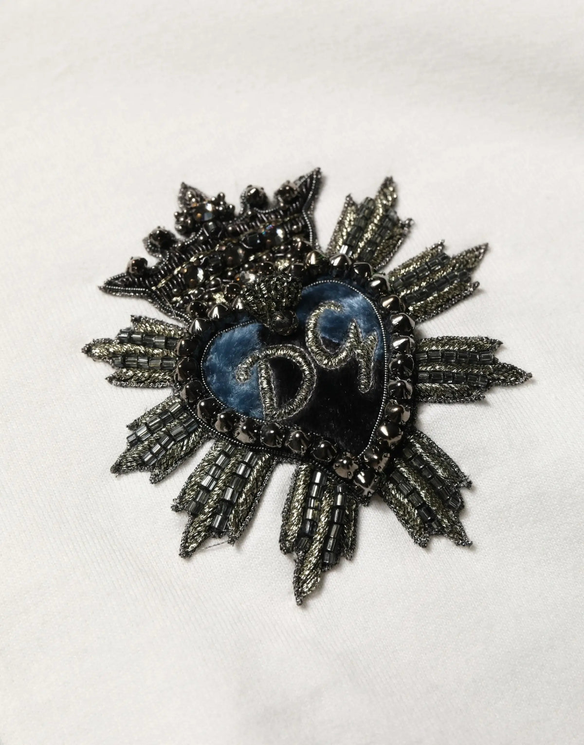 Broche en forme de cœur sombre perlée avec centre bleu et broderie argentée sur sweat à capuche blanc en coton dolce & gabbana