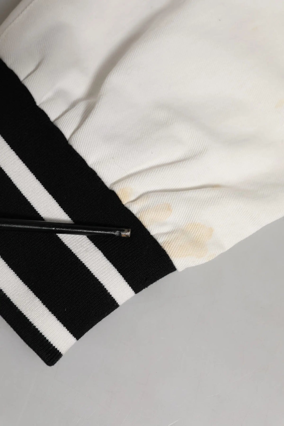 Manche de veste varsity blanche et noire avec poignets côtelés à deux bandes blanches sur pantalon cargo ajusté en coton dolce & gabbana