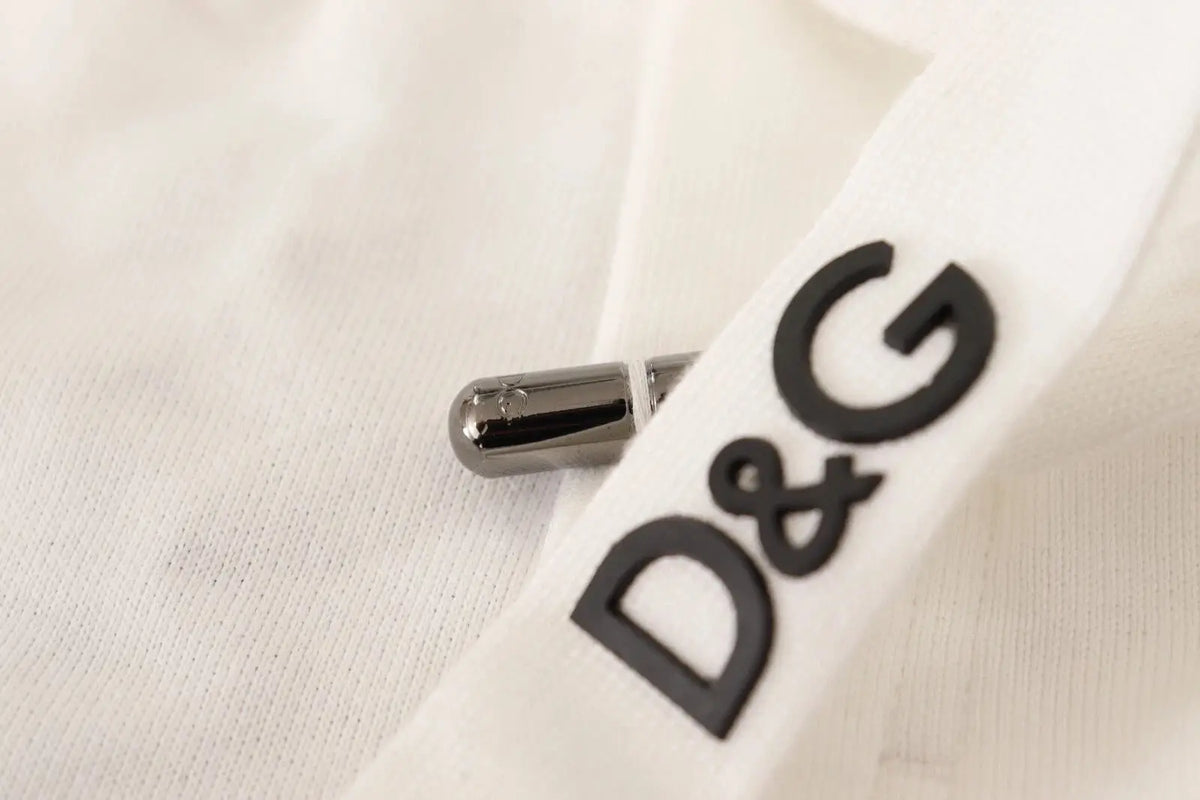 Bouton argenté métallique à finition polie à côté du logo noir d&g sur tissu blanc des jogging dolce & gabbana