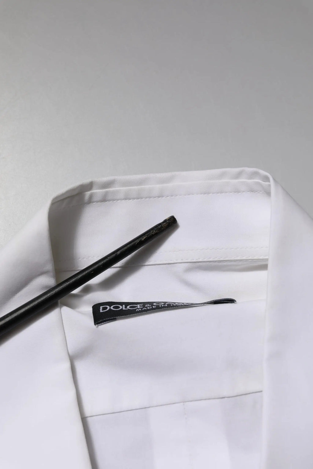 Col blanc dolce gabbana en coton avec col de chemise et étiquette noire visible sur une chemise formelle à manches longues