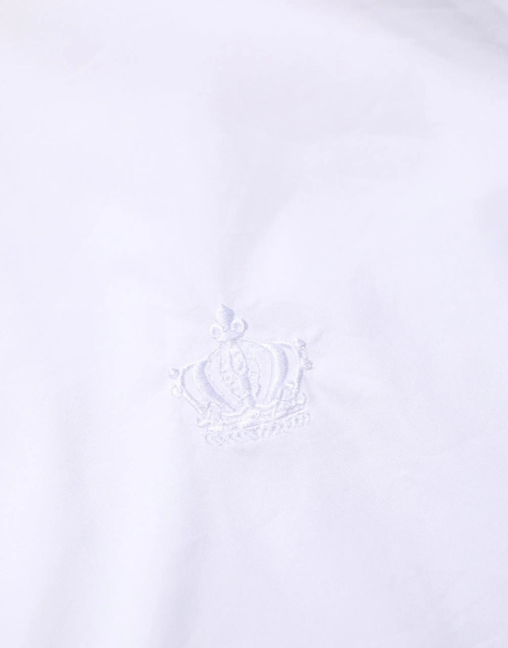 Logo couronne brodé blanc sur tissu blanc net sur chemise habillée homme blanche coton dolce gabbana martini