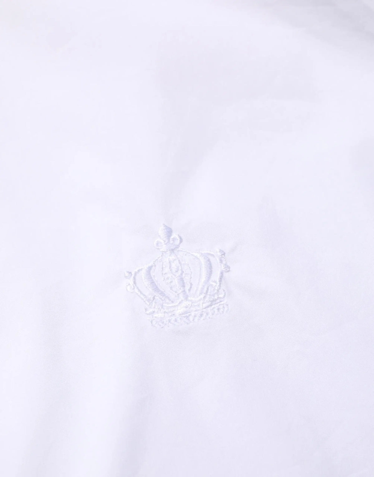 Logo couronne brodé blanc sur tissu blanc net sur chemise habillée homme blanche coton dolce gabbana martini