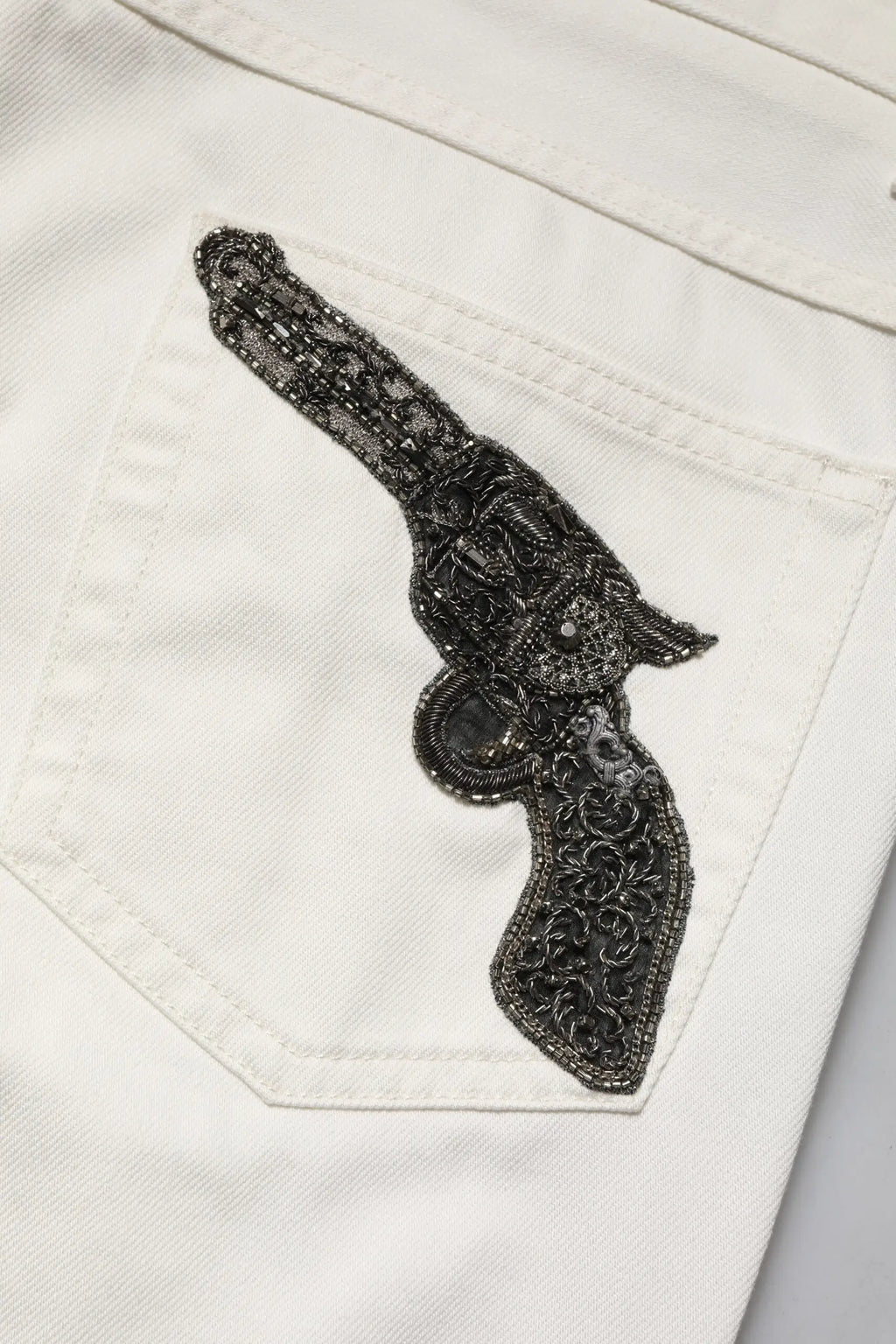 Patch revolver en perles noires sur poche en denim blanc cassé des jeans skinny pour homme en coton dolce & gabbana