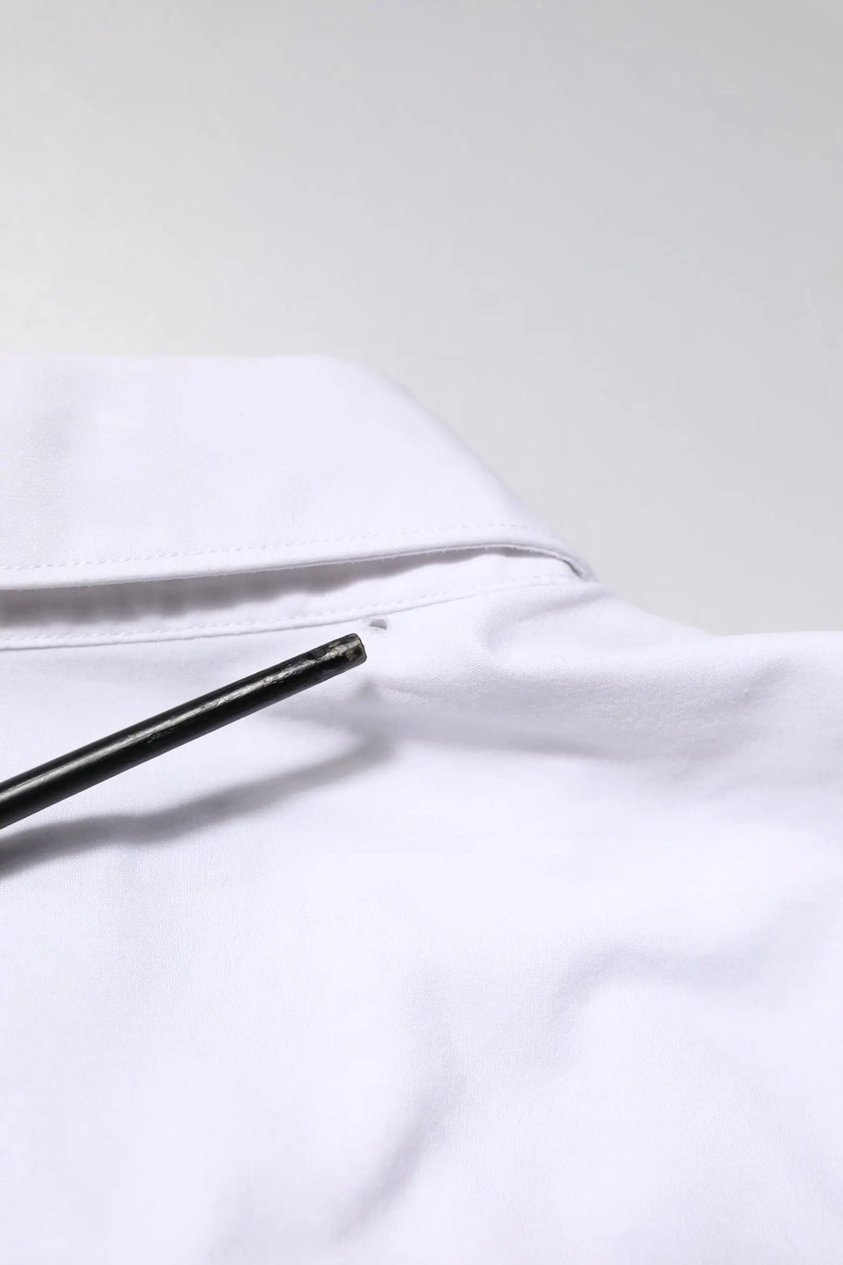Col blanc en coton de la chemise formelle à manches longues staff dolce & gabbana avec un stylo noir appuyé dessus