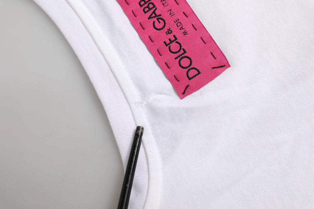 Étiquette rose vif dolce & gabbana made in italy cousue sur t-shirt blanc dolce & gabbana orné de fleurs d&g
