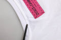 Étiquette rose vif dolce & gabbana made in italy cousue sur t-shirt blanc dolce & gabbana orné de fleurs d&g