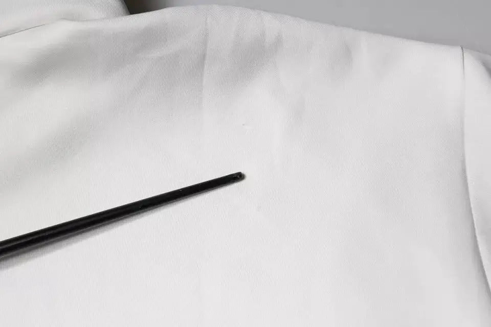 Crochet noir posé sur un tissu blanc à côté d’un sweat à capuche blanc dolce & gabbana logo d&g homme