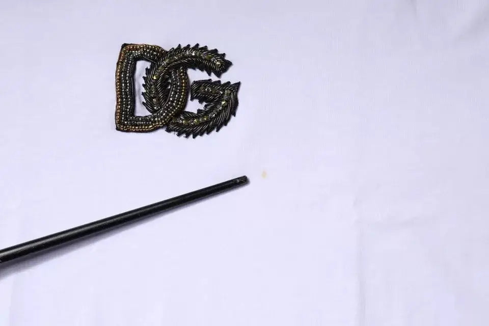 Dolce & gabbana t-shirt coton blanc avec broche logo dg perlée noire et détails plume dorés