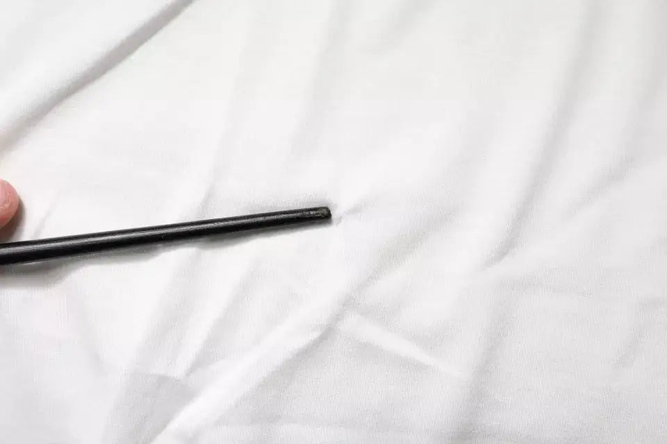 Crayon cylindrique noir mat présenté avec un t-shirt dolce & gabbana blanc en coton à col rond avec logo dg