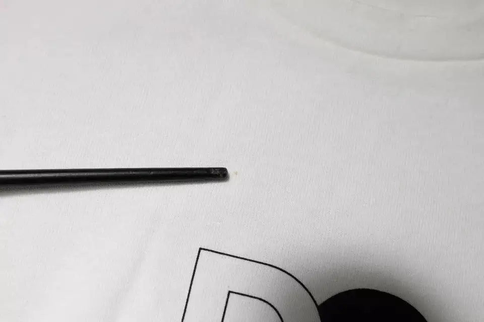 Black chopstick reposant sur tissu blanc avec t-shirt dolce & gabbana blanc logo dg col rond manches courtes