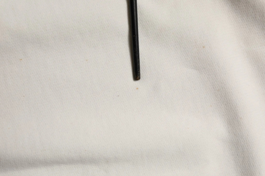 Objet cylindrique noir accompagné d’un sweatshirt dolce & gabbana blanc à col rond avec logo dg