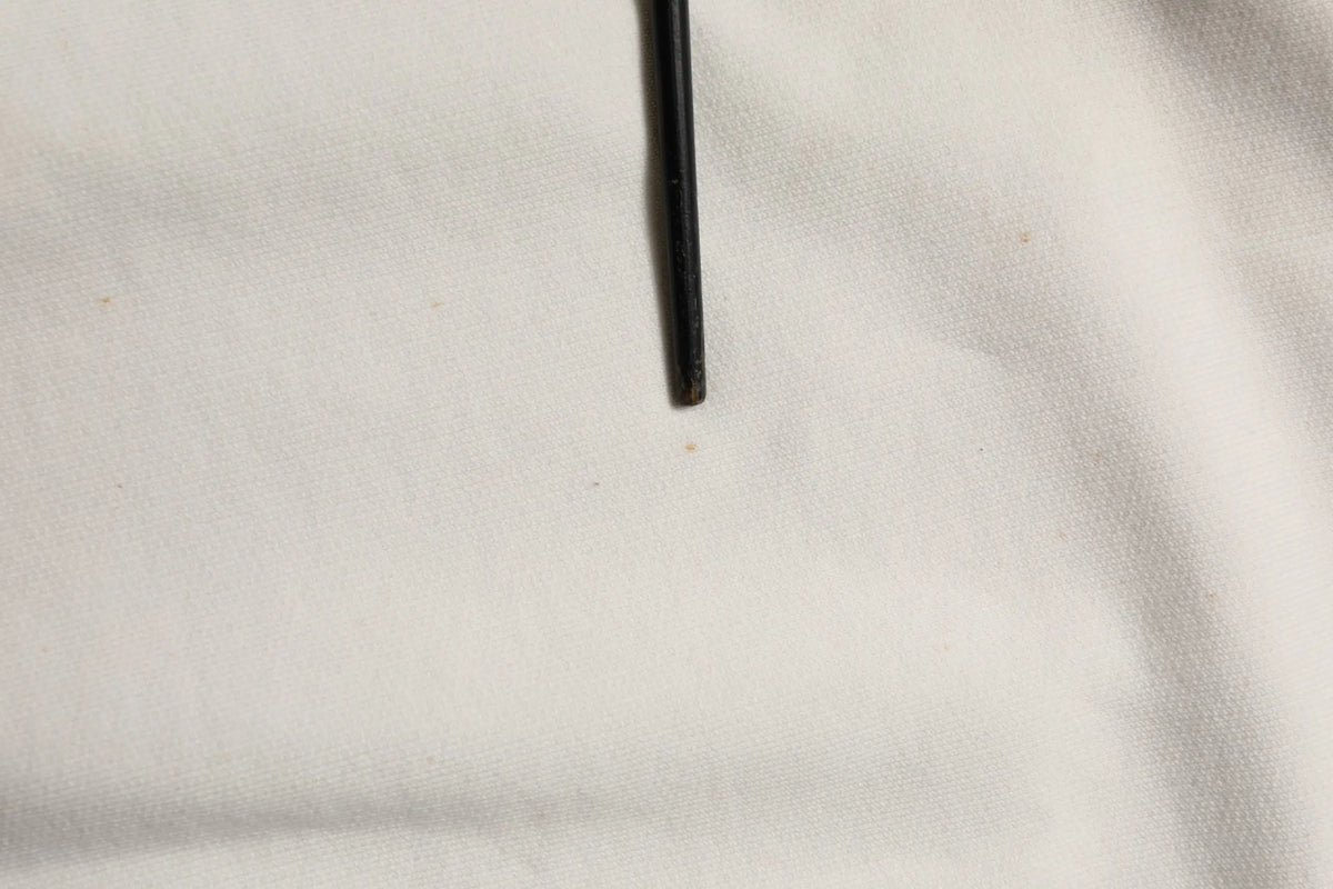Objet cylindrique noir accompagné d’un sweatshirt dolce & gabbana blanc à col rond avec logo dg
