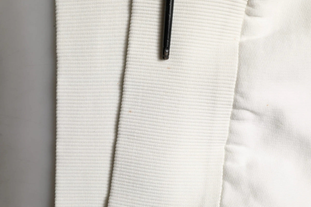 Sweatshirt dolce & gabbana blanc en maille côtelée avec logo dg avec un stylo noir posé dessus