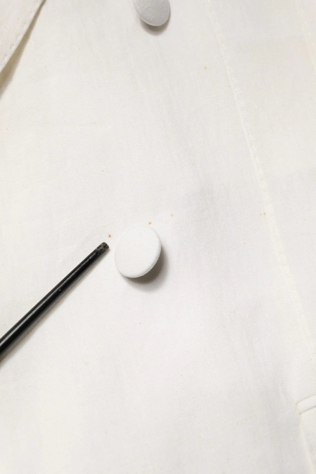 Bouton blanc circulaire sur tissu clair pour manteau trench homme blanc double boutonnage dolce gabbana