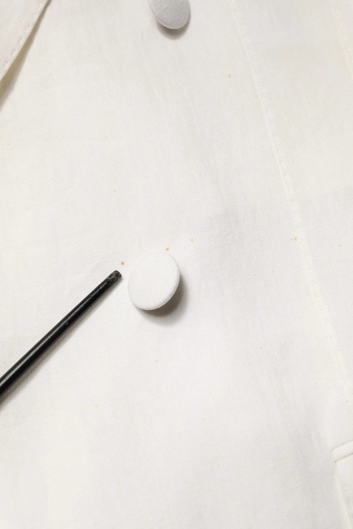 Bouton blanc circulaire sur tissu clair pour manteau trench homme blanc double boutonnage dolce gabbana