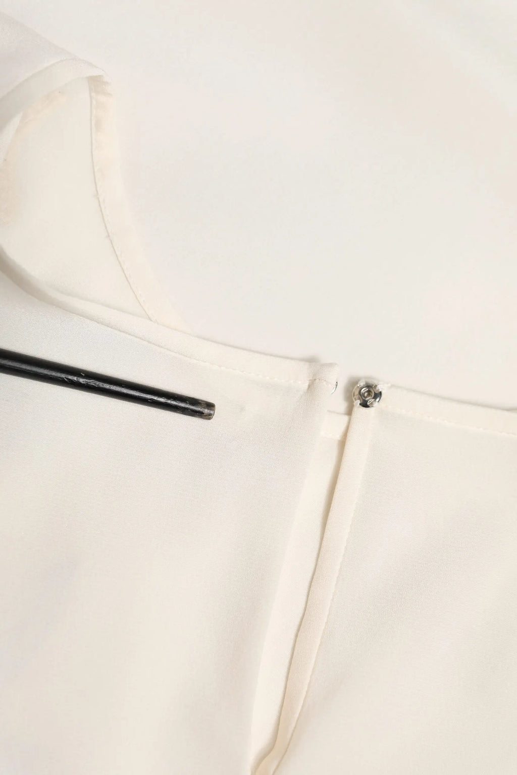 Blouse en satin blanc cassé dolce et gabbana avec un petit bouton métallique au col et un léger éclat