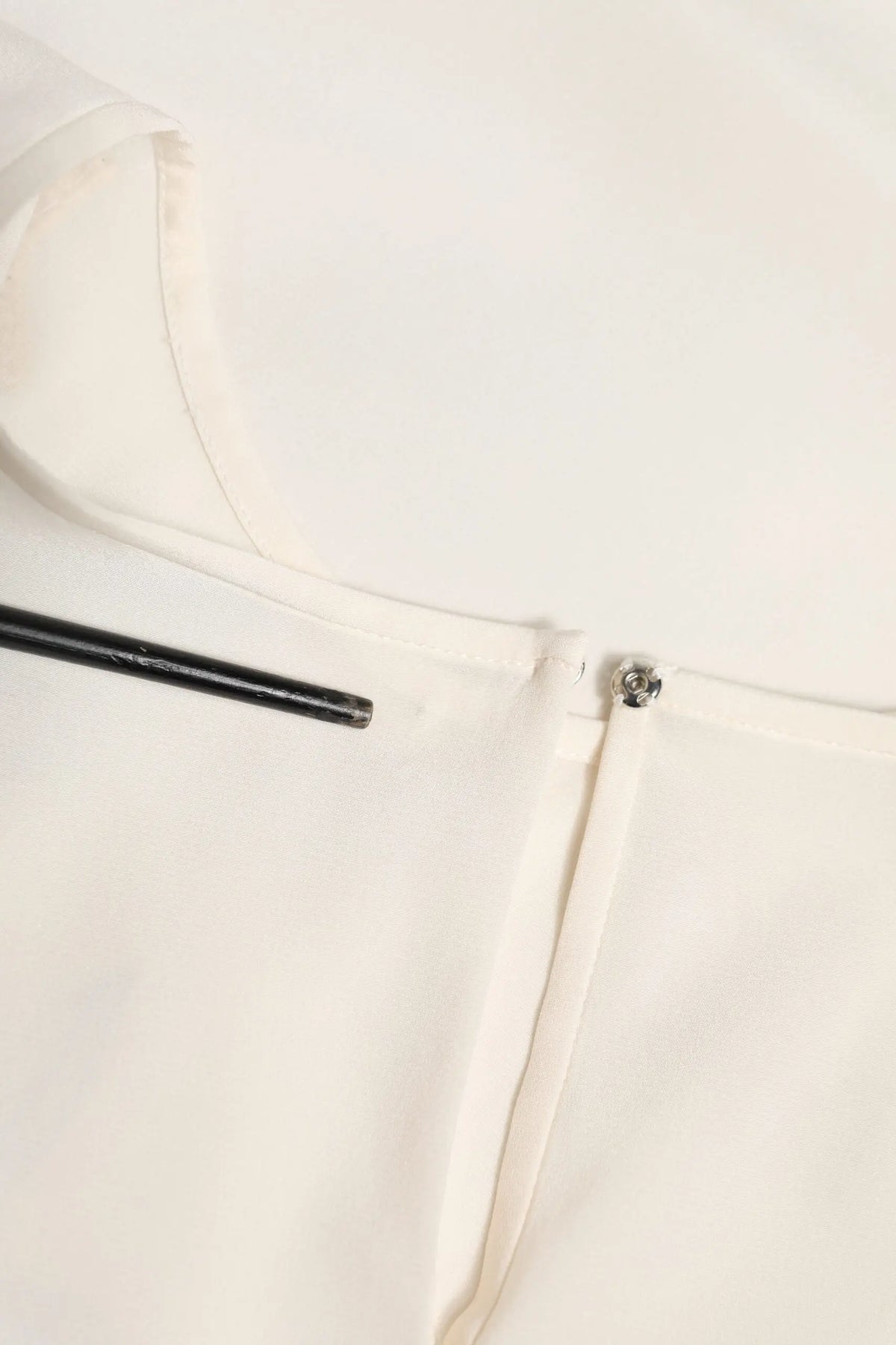 Blouse en satin blanc cassé dolce et gabbana avec un petit bouton métallique au col et un léger éclat