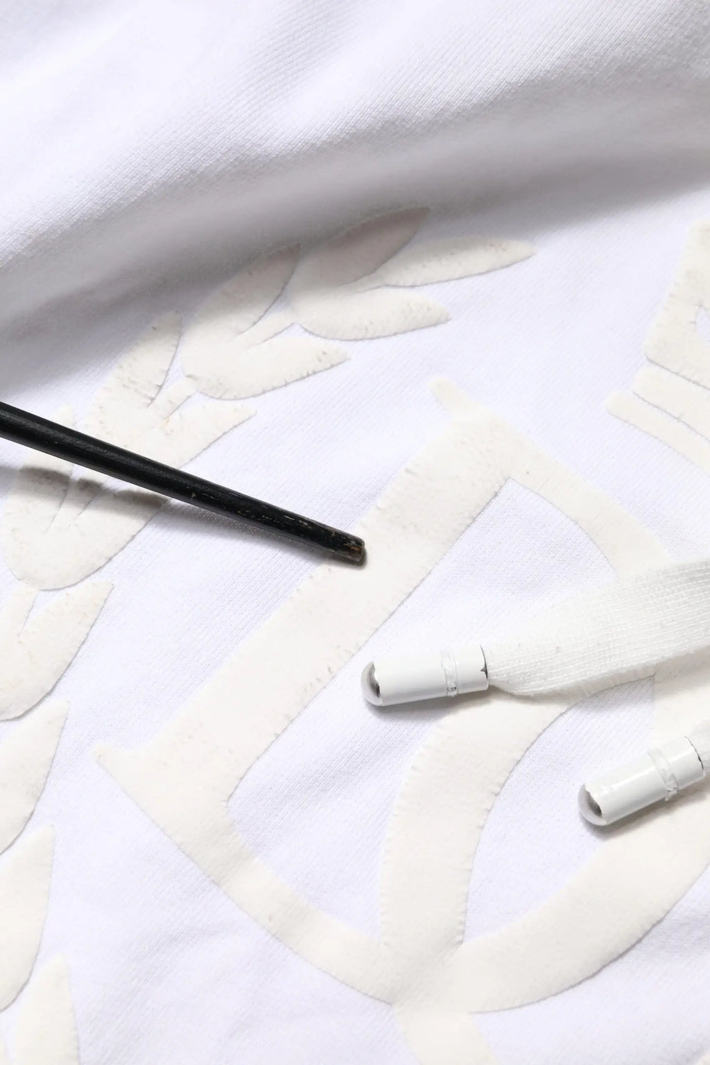Sweat à capuche dolce & gabbana blanc en tissu embossé avec motif feuilles brodées et pinceau noir à côté
