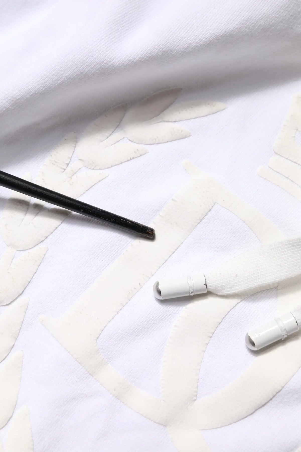 Sweat à capuche dolce & gabbana blanc en tissu embossé avec motif feuilles brodées et pinceau noir à côté