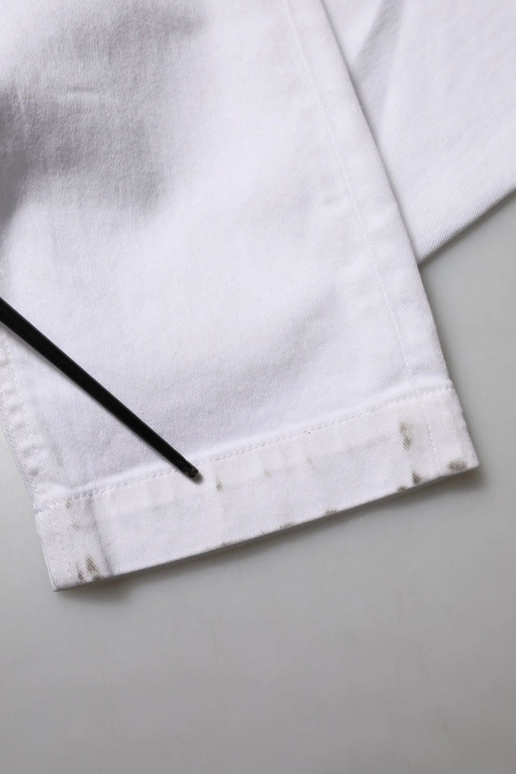 Poignet en tissu coton blanc avec couture visible et légère décoloration sur le jean denim dolce & gabbana brodé floral