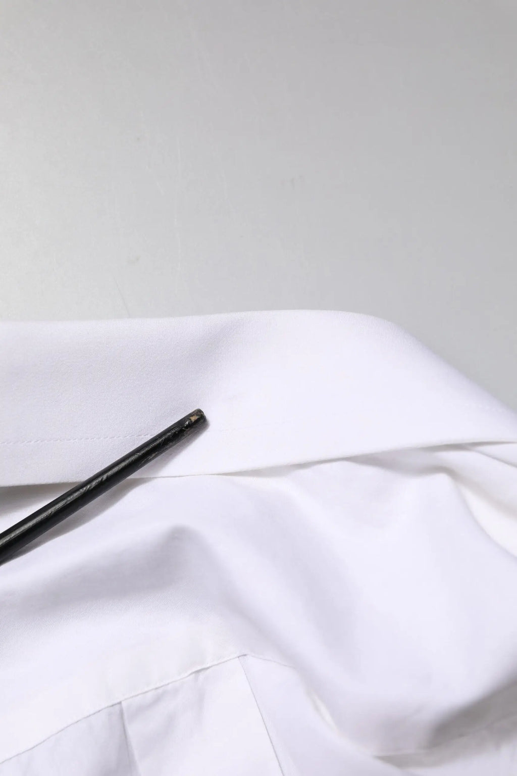 Col blanc en coton de la chemise formelle à manches longues dolce gabbana avec un crayon noir élégant posé en diagonale