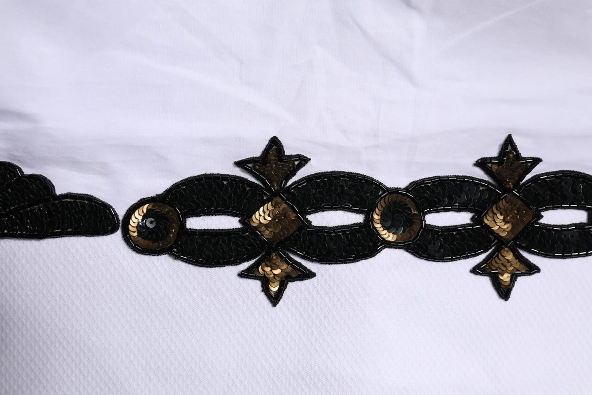 Détail de bordure décorative noire et or à sequins avec étoiles sur chemise homme formelle blanche dolce & gabbana gold