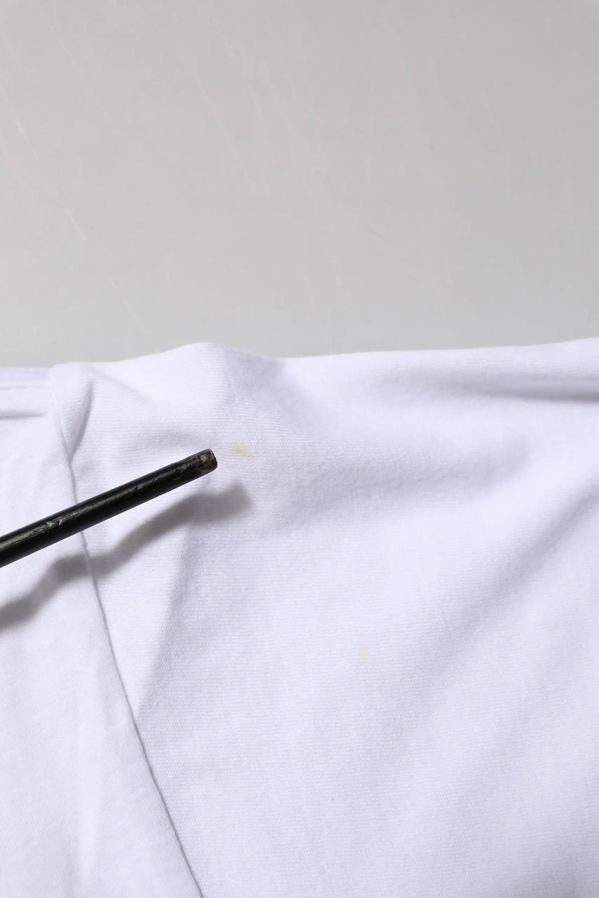 Crayon noir reposant sur un tissu blanc du t-shirt Dolce & Gabbana en coton à imprimé graphique blanc col rond