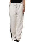 Pantalon de jogging dolce & gabbana blanc crème avec bandes noires verticales et logo de la marque imprimé