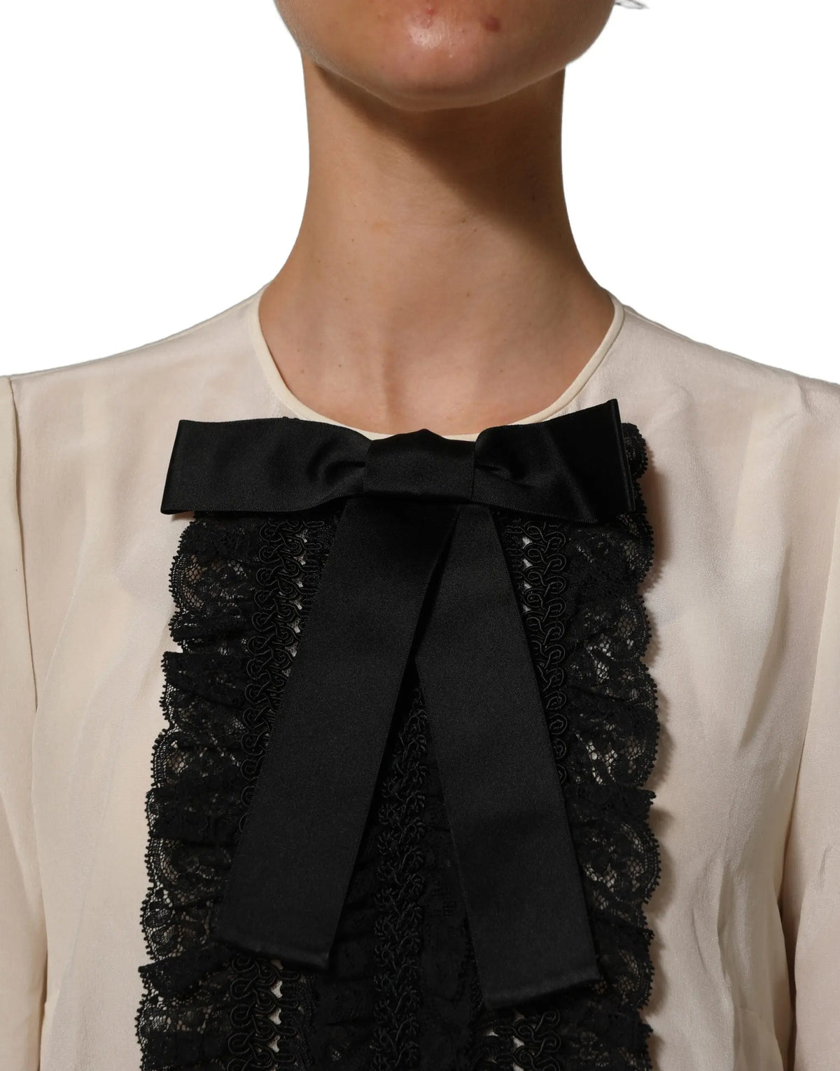 Noeud en satin noir avec dentelle délicate centré sur un chemisier crème dolce & gabbana manches courtes