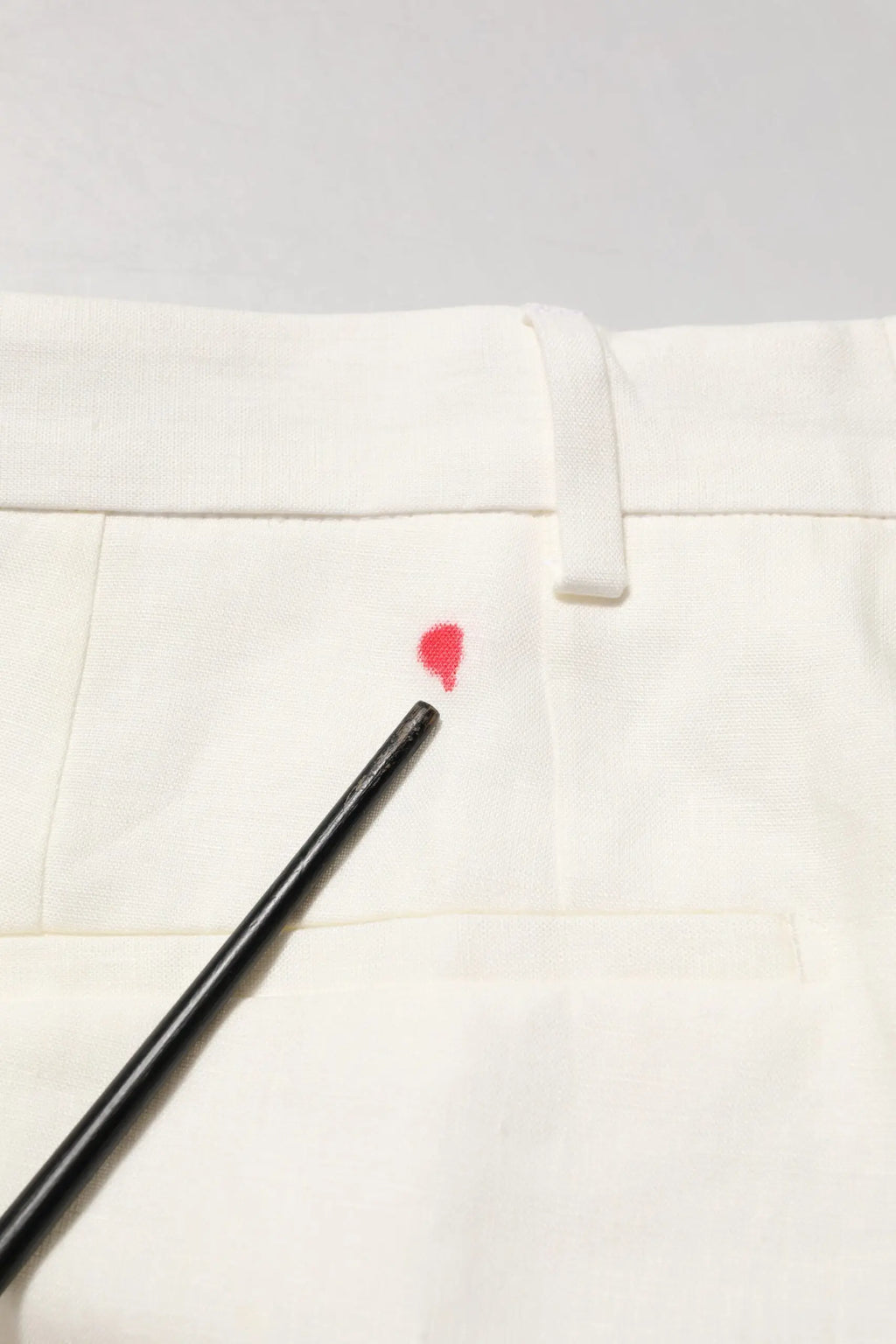 Petite tache en forme de coeur rouge vif sur pantalon blanc en lin formel pour homme dolce gabbana