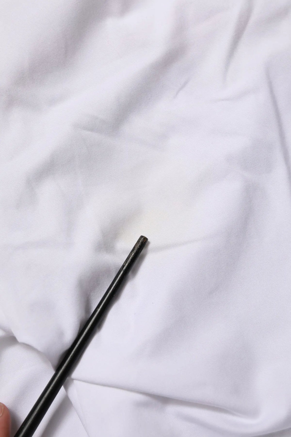 Chopsticks noirs reposant sur un tissu blanc près d un pantalon cargo droit en lin blanc pour homme dolce gabbana