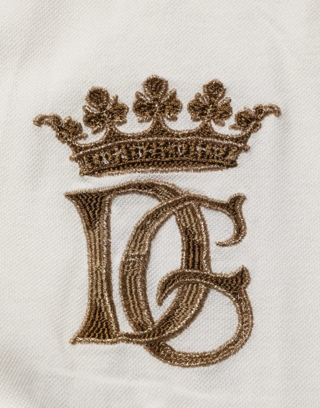 Polo en coton blanc dolce & gabbana avec couronne brodée en or et monogramme logo sur le tissu