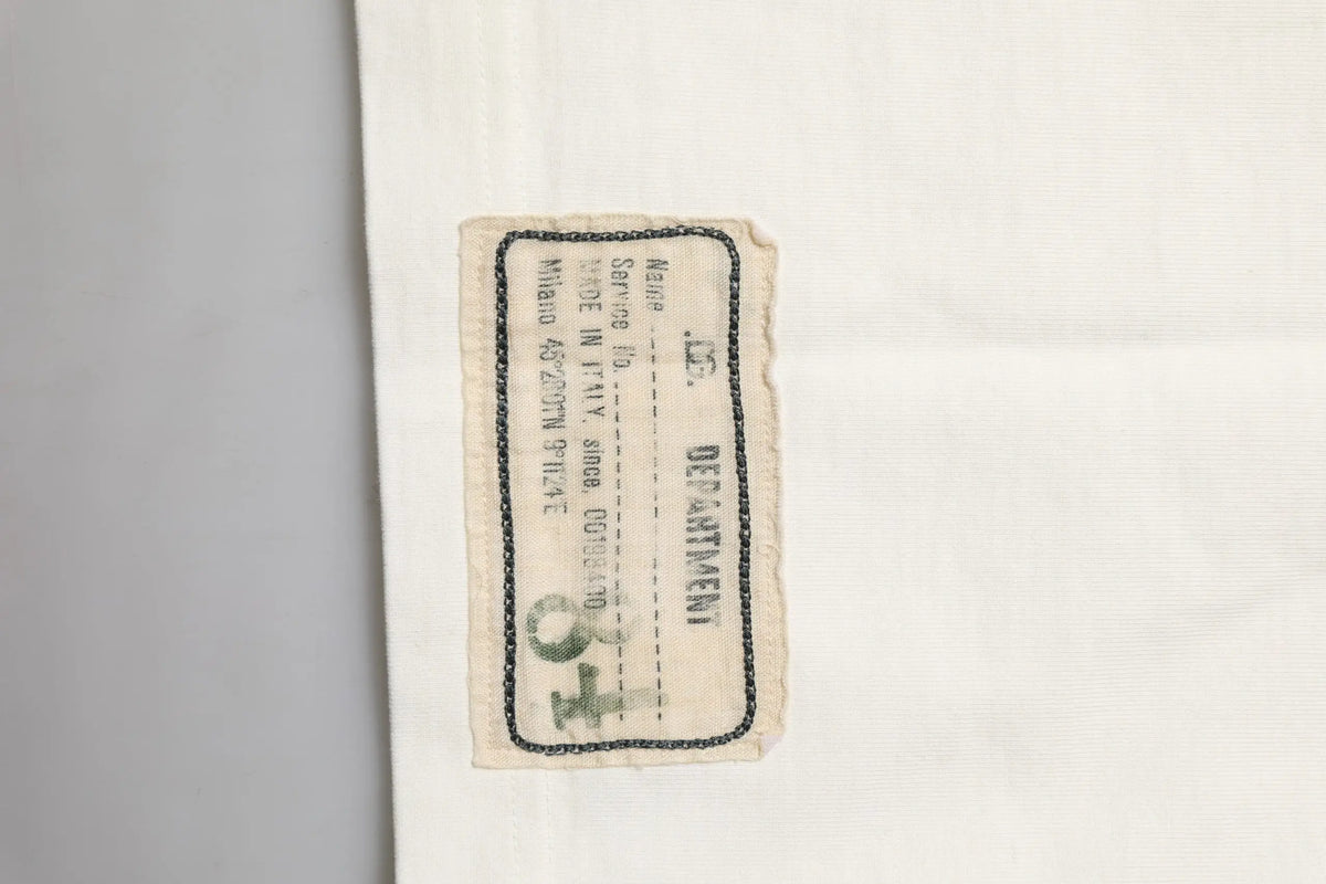 Étiquette en tissu beige usée avec bordure noire et texte imprimé department en majuscules sur t-shirt homme dolce & gabbana blanc coton col rond