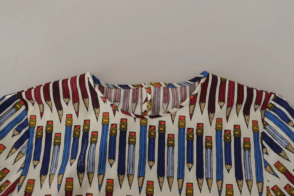 Blouse en coton blanche dolce & gabbana avec imprimé de crayons bleus et rouges et détails dorés sur les gommes