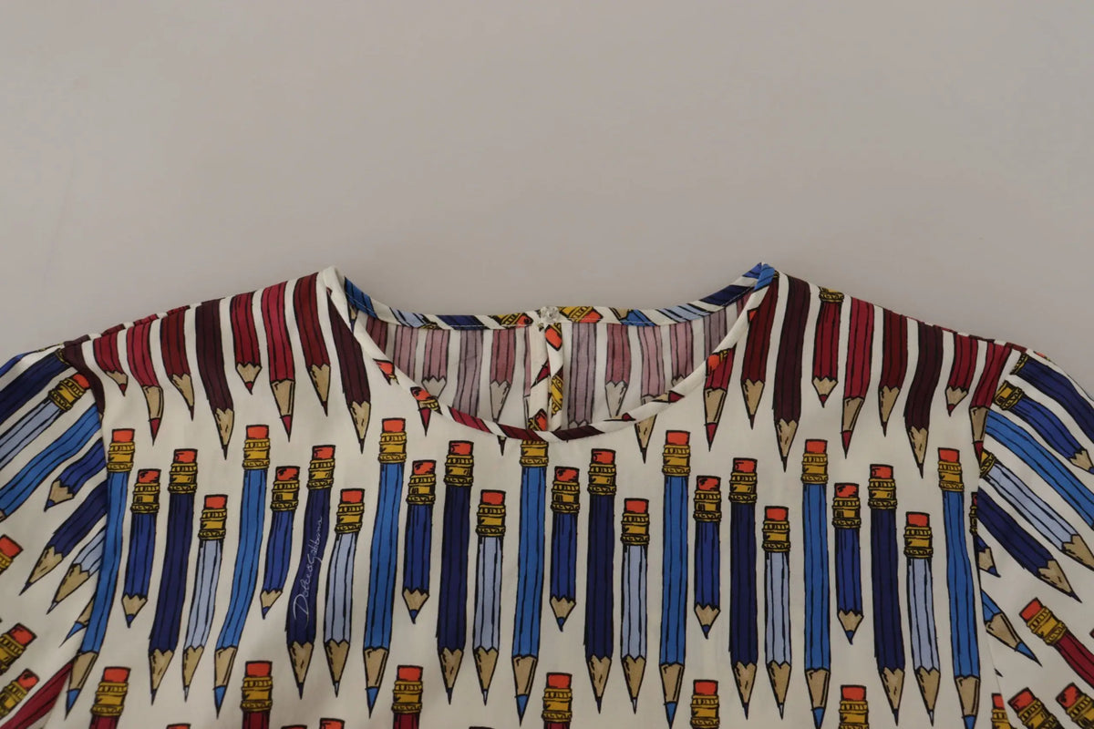 Blouse en coton blanche dolce & gabbana avec imprimé de crayons bleus et rouges et détails dorés sur les gommes