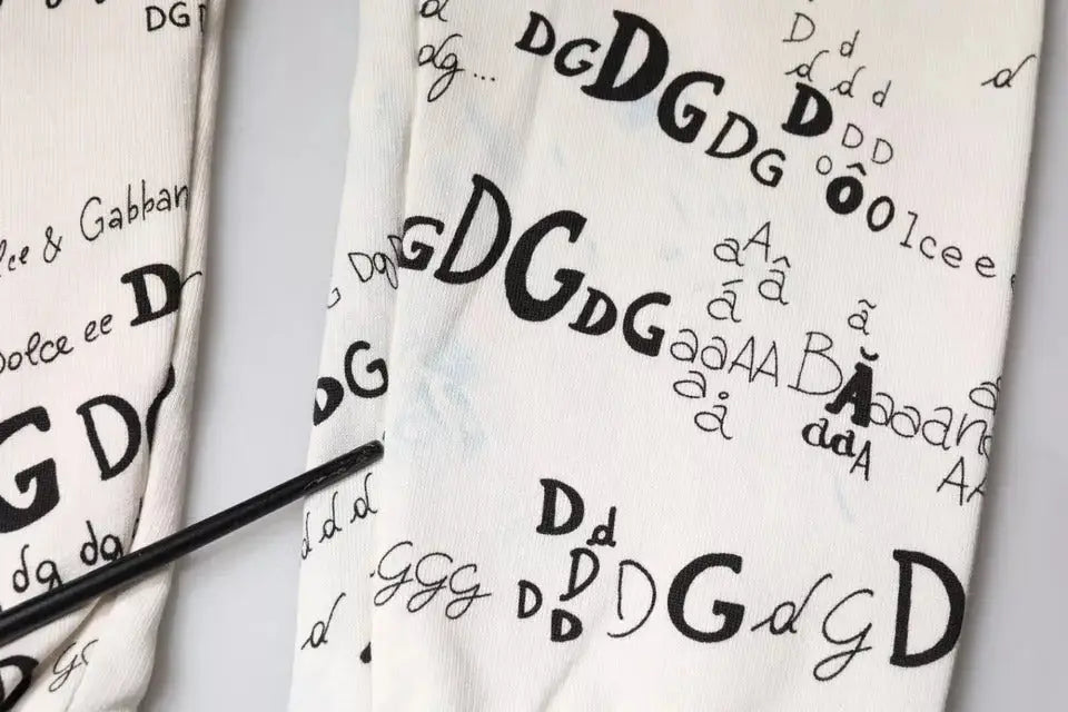 Sac fourre-tout en tissu blanc dolce & gabbana avec motif répétitif de lettres et symboles noirs dg