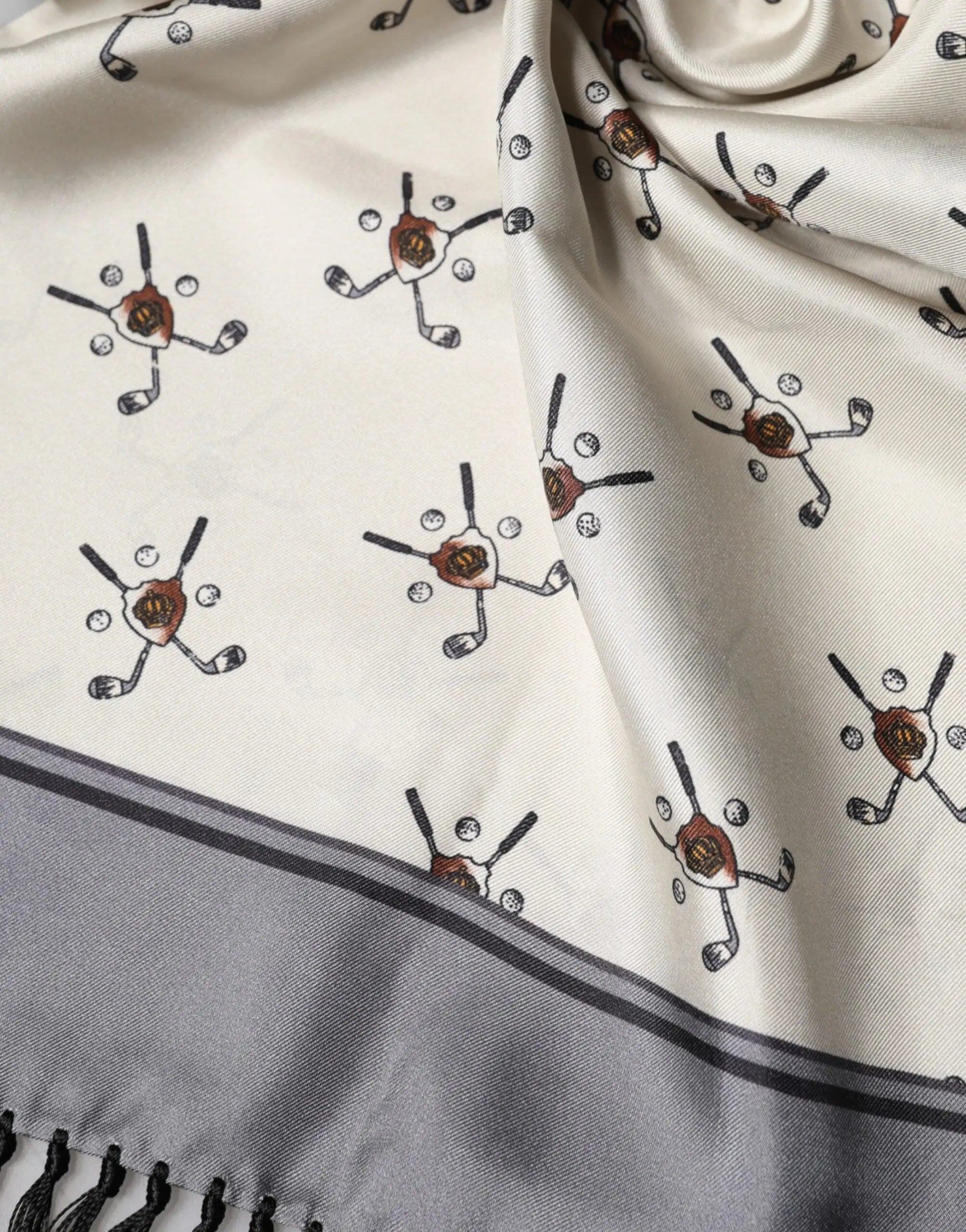 Dolce & Gabbana foulard pour homme blanc crème avec motifs golfeurs, bordure grise et franges noires, 183x33 cm