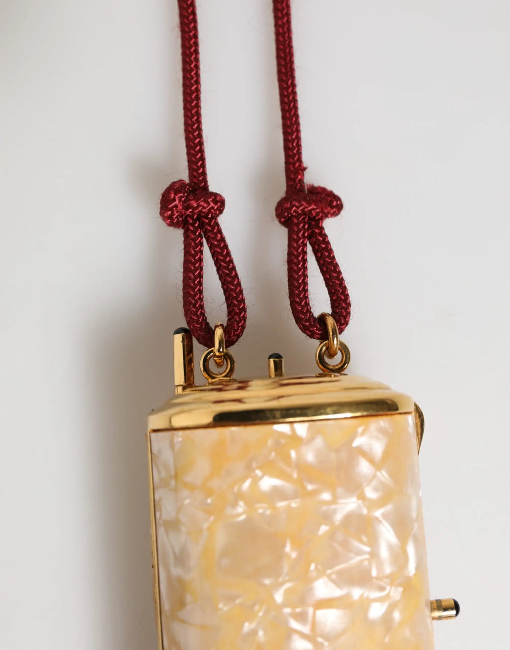 Pochette rectangulaire dolce & gabbana en résine blanche irisée avec garniture métal or et cordons tressés bordeaux