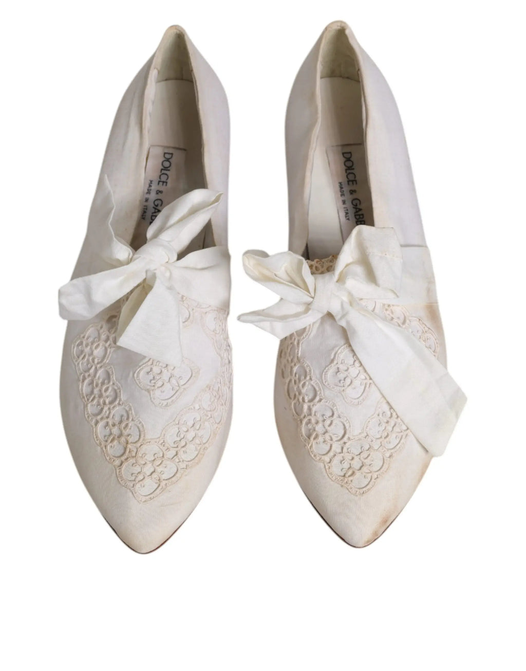 Une paire de ballerines dolce & gabbana blanches en tissu avec broderie en dentelle et grand nœud en satin à l’avant