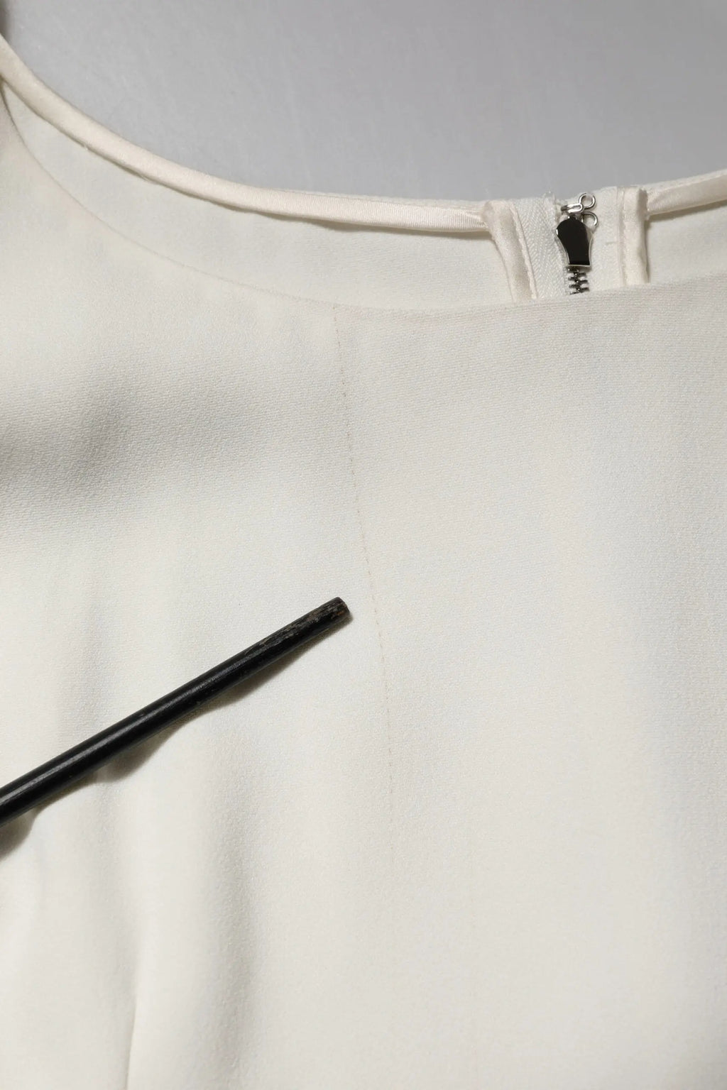 Un top blanc dolce & gabbana en satin avec un col rond, manches courtes et une fermeture éclair noire au col