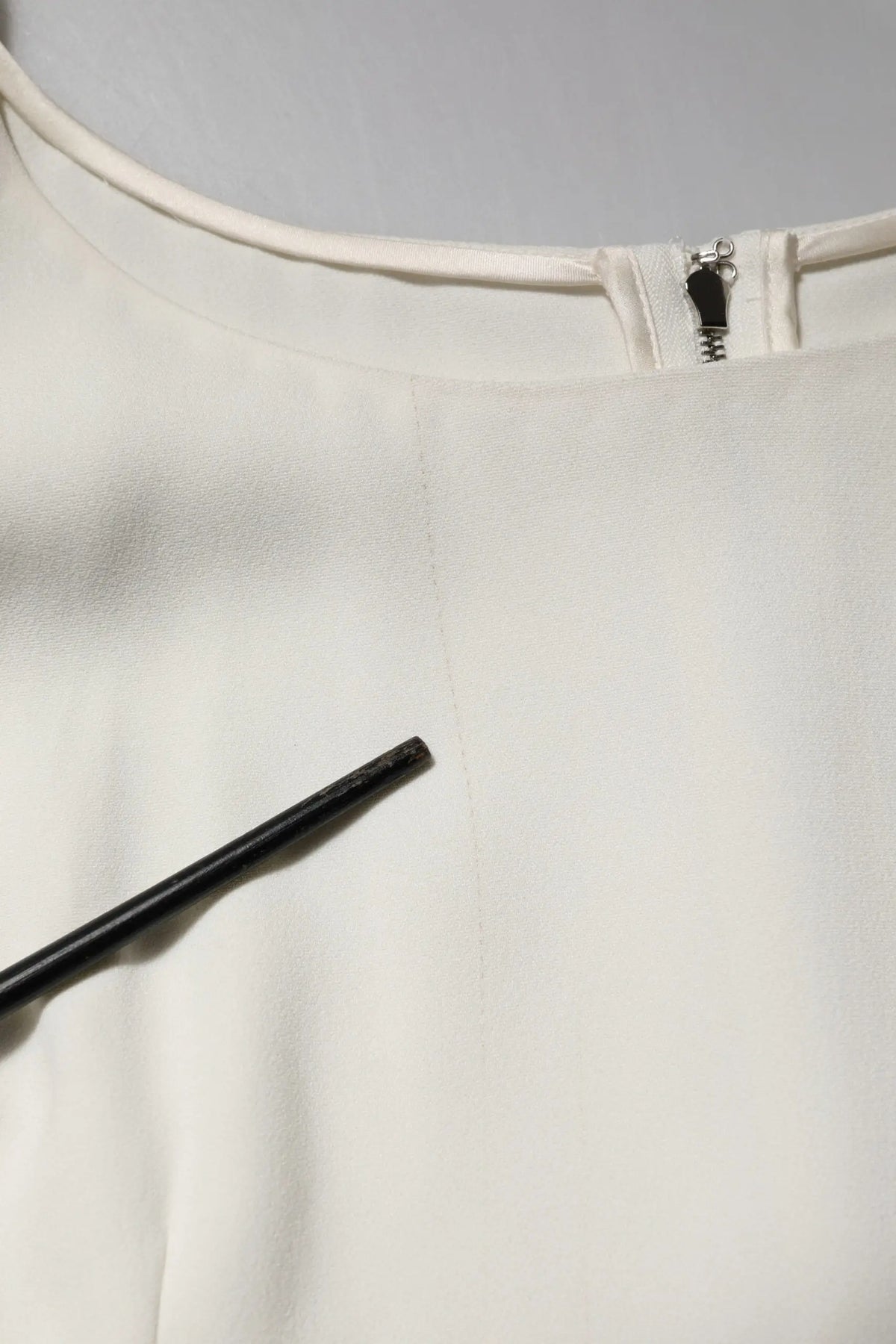 Un top blanc dolce & gabbana en satin avec un col rond, manches courtes et une fermeture éclair noire au col