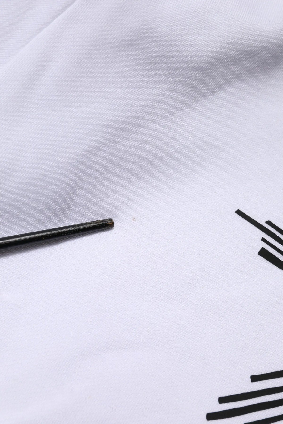 Chopsticks noirs reposant sur un tissu blanc à motifs géométriques noirs avec sweat à capuche blanc dolce & gabbana sacred heart