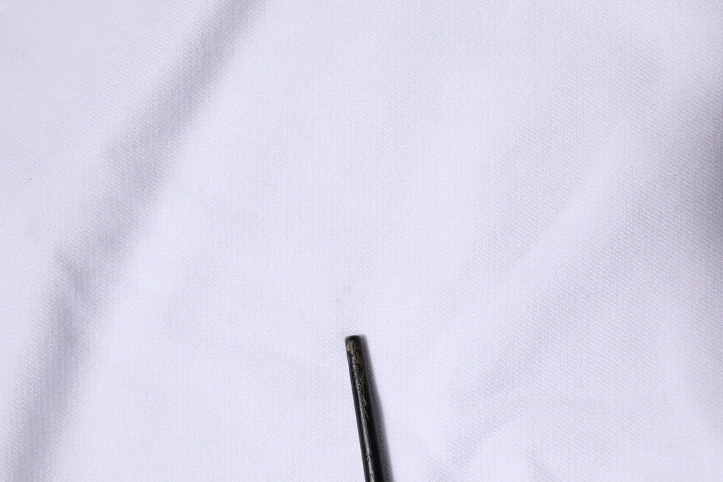 Détail de la pointe cylindrique noire du stylo sur le sweat à capuche blanc dolce & gabbana sacred heart