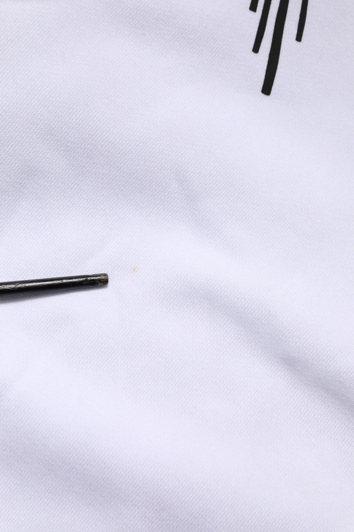Aiguille métallique noire légèrement usée posée sur tissu blanc du sweat à capuche dolce gabbana white sacred heart