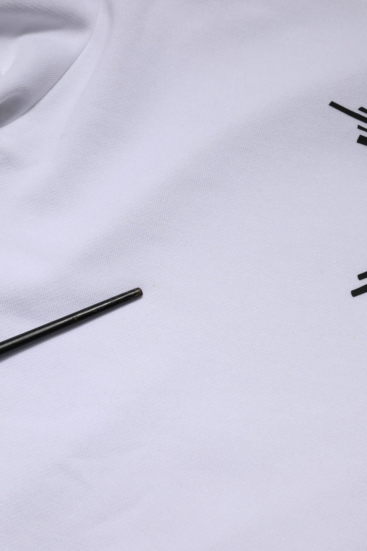 Stylo cylindrique noir reposant sur tissu blanc en sweat à capuche blanc dolce & gabbana sacred heart