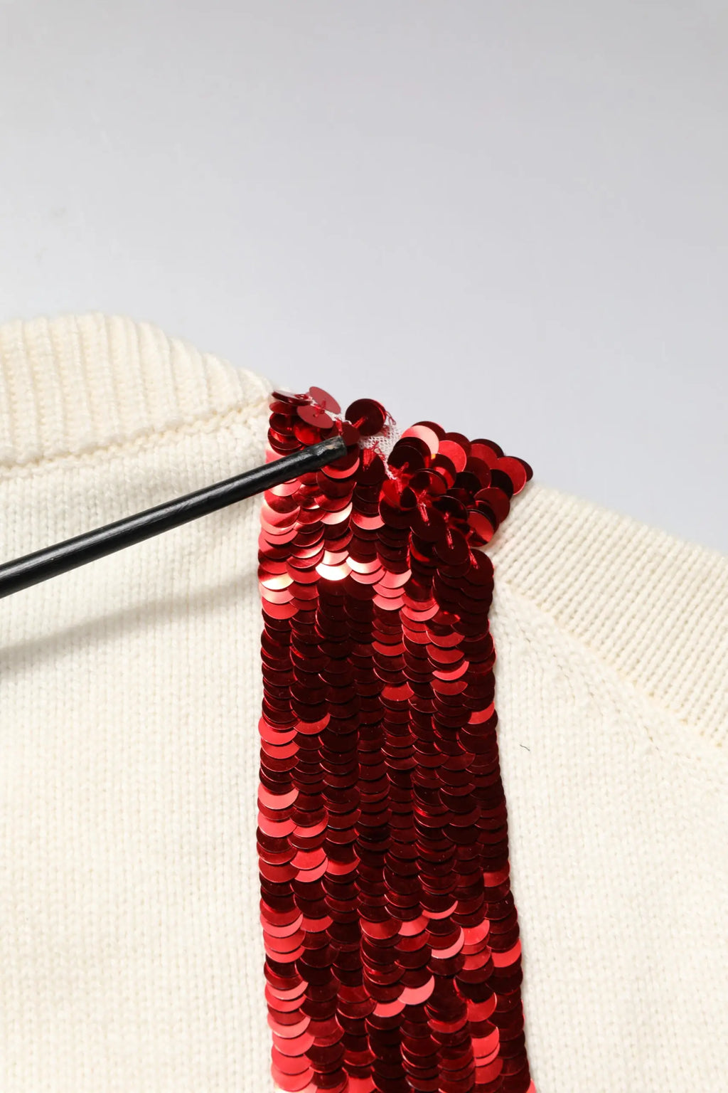 Pull-over blanc dolce & gabbana en maille avec bande rouge vif à sequins sur l’épaule
