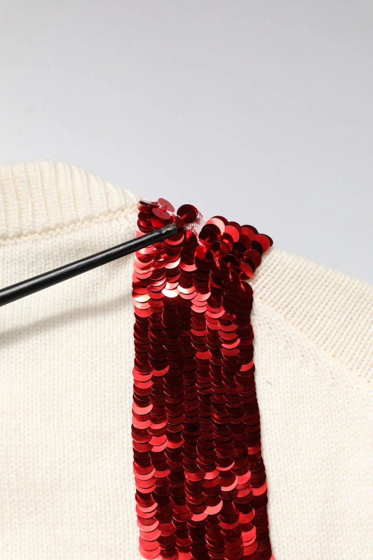 Pull-over blanc dolce & gabbana en maille avec bande rouge vif à sequins sur l’épaule