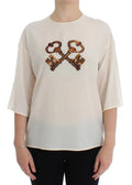 Blouse en soie crème dolce & gabbana avec croix audacieuse de clés en laiton ancien à sequins sur la poitrine